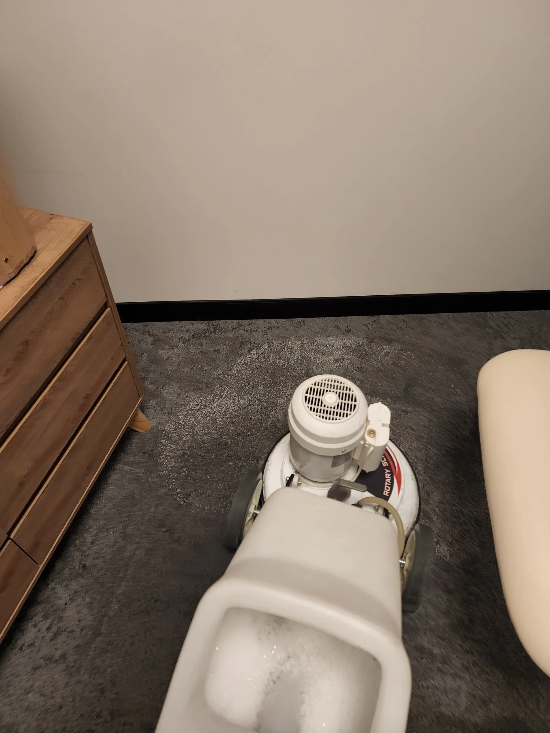 Rotary carpet machine working on a dark commercial carpet